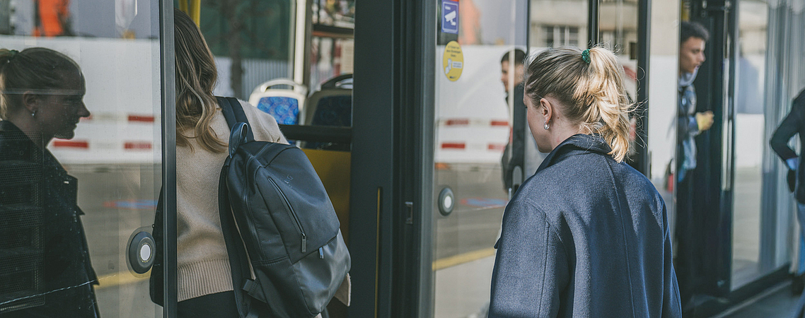 Passantinnen und Passanten die an einem sonnigen Tag an einer Haltestelle in einen Trolleybus der Verkehrsbetriebe Luzern AG einsteigen.